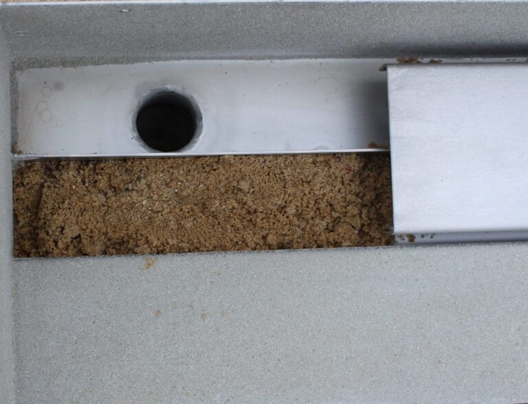 Aquanau-Edelstahl-Duschrinne mit beidseitigem Sandfang und umlaufendem flachem Dichtflansch für den Einbau in der Raummitte, ohne Abdeckung dargestellt.